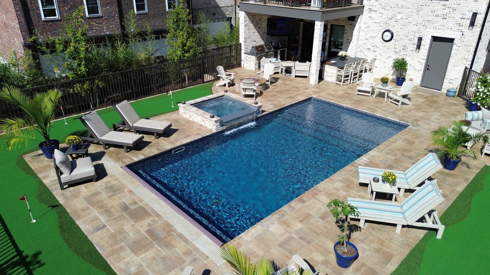 Luxury backyard in Nashville with custom gunite pool, spillover spa, firepit, outdoor kitchen, putting green, and sound system