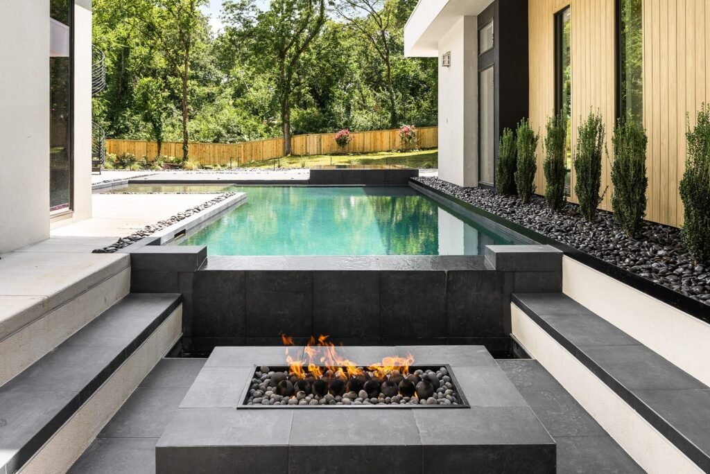 Sunken fire lounge beside a modern courtyard pool