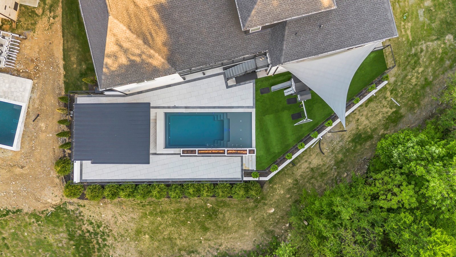 Aerial view of a pool, patio and turf